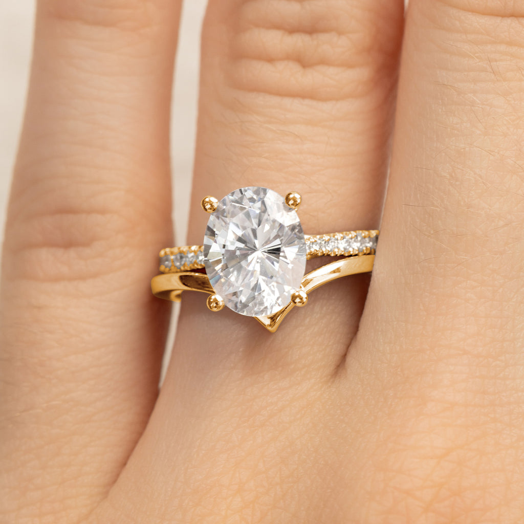 An oval diamond solitaire engagement ring paired with a V-shaped pavé wedding band in 18K yellow gold. Canadian-made.