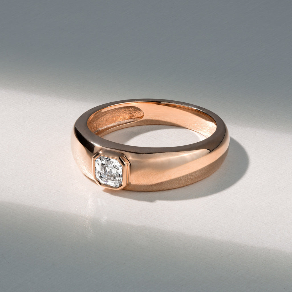 Canadian-made 14K rose gold engagement ring with a bezel-set Asscher cut diamond on a thick band.