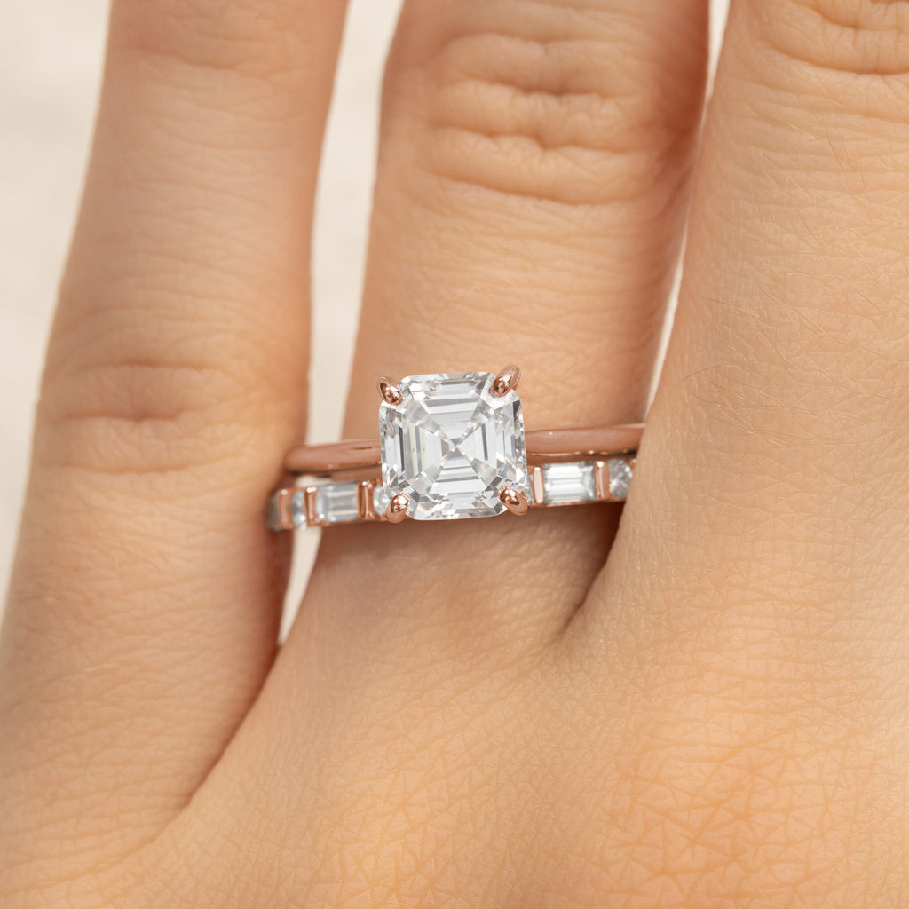 A Canadian-made bridal set with an Asscher cut diamond engagement ring and baguette wedding band in 14K rose gold.
