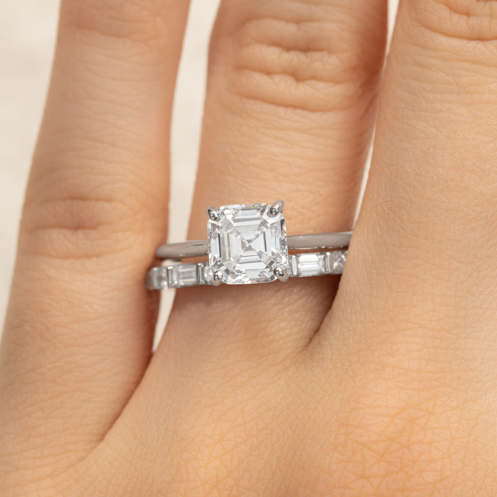 An Asscher-cut diamond engagement ring stacked with a baguette diamond wedding ring in Canadian-made 18K white gold.