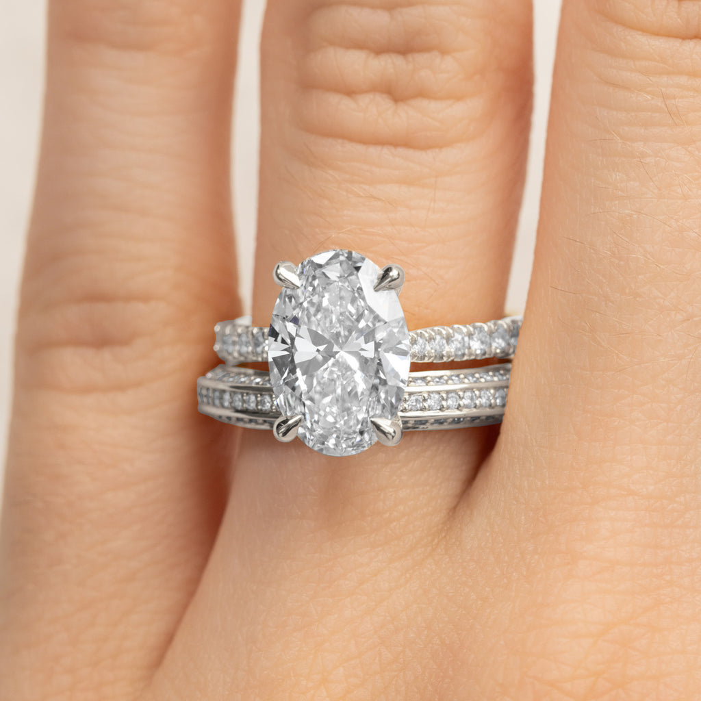 Canadian-made bridal set with an oval diamond engagement ring and matching pavé wedding ring in 18K white gold.