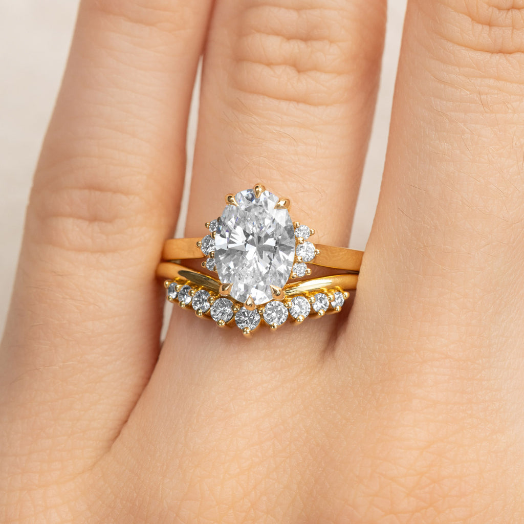 Canadian-made oval diamond engagement ring with a matching curved wedding band in 18K yellow gold.