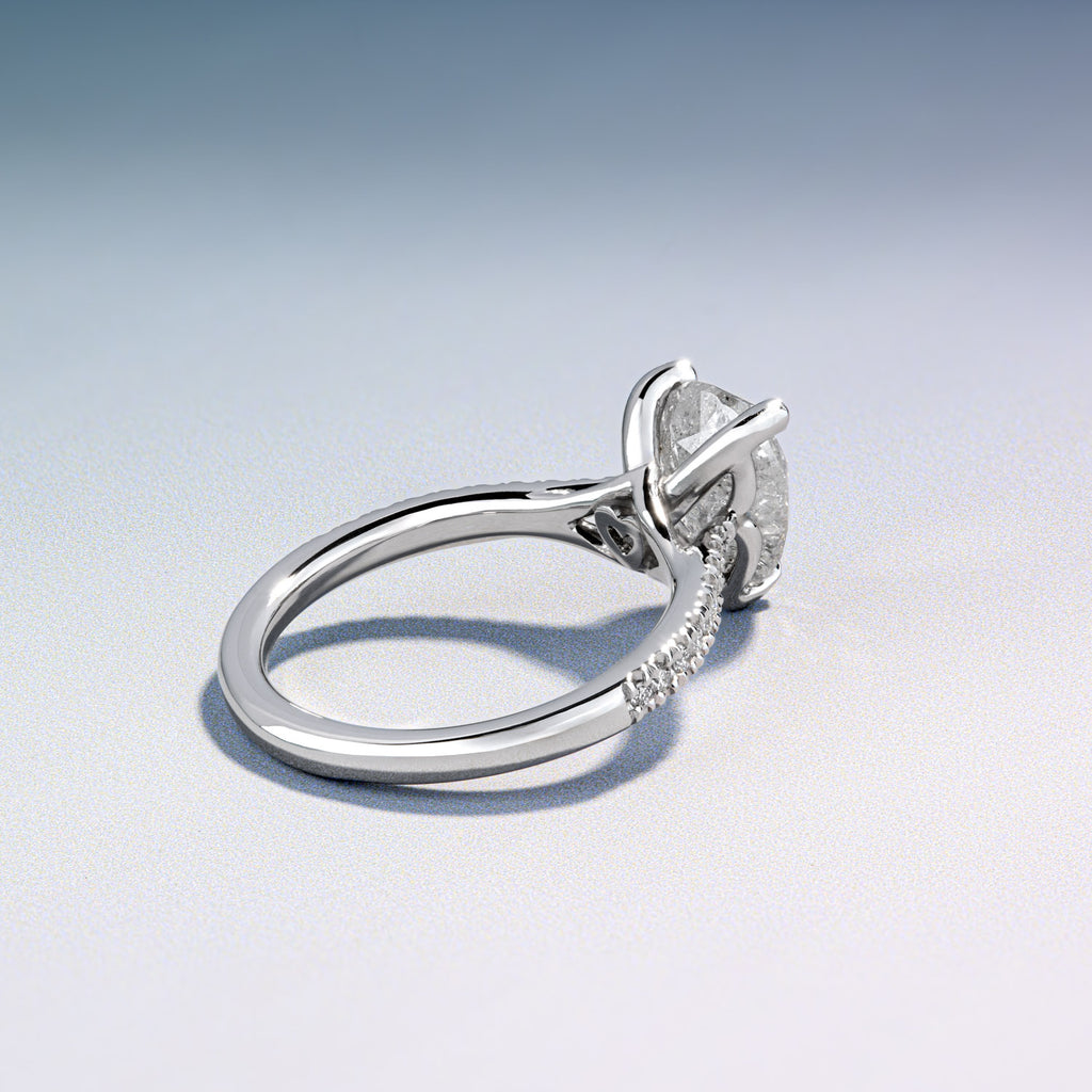 Canadian-made round diamond engagement ring in 18K white gold with a delicate pavé diamond band.
