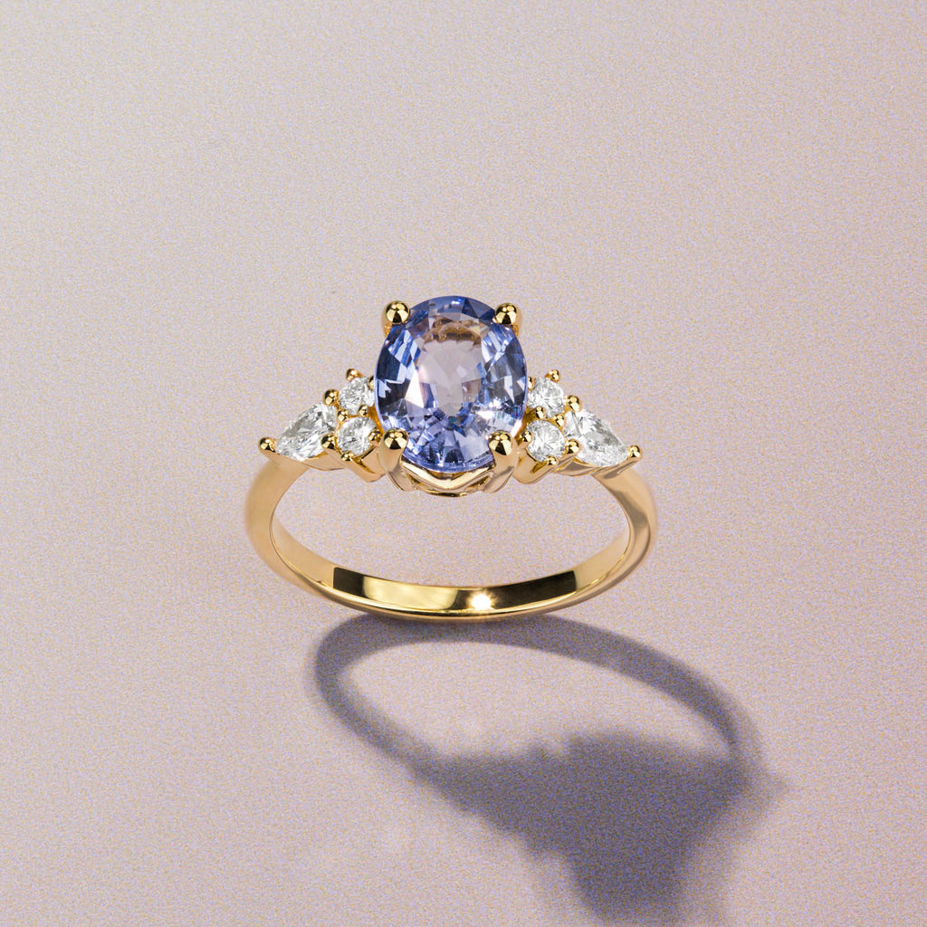 Canadian-made oval sapphire engagement ring with pear and round diamond accents on an 18K yellow gold band.