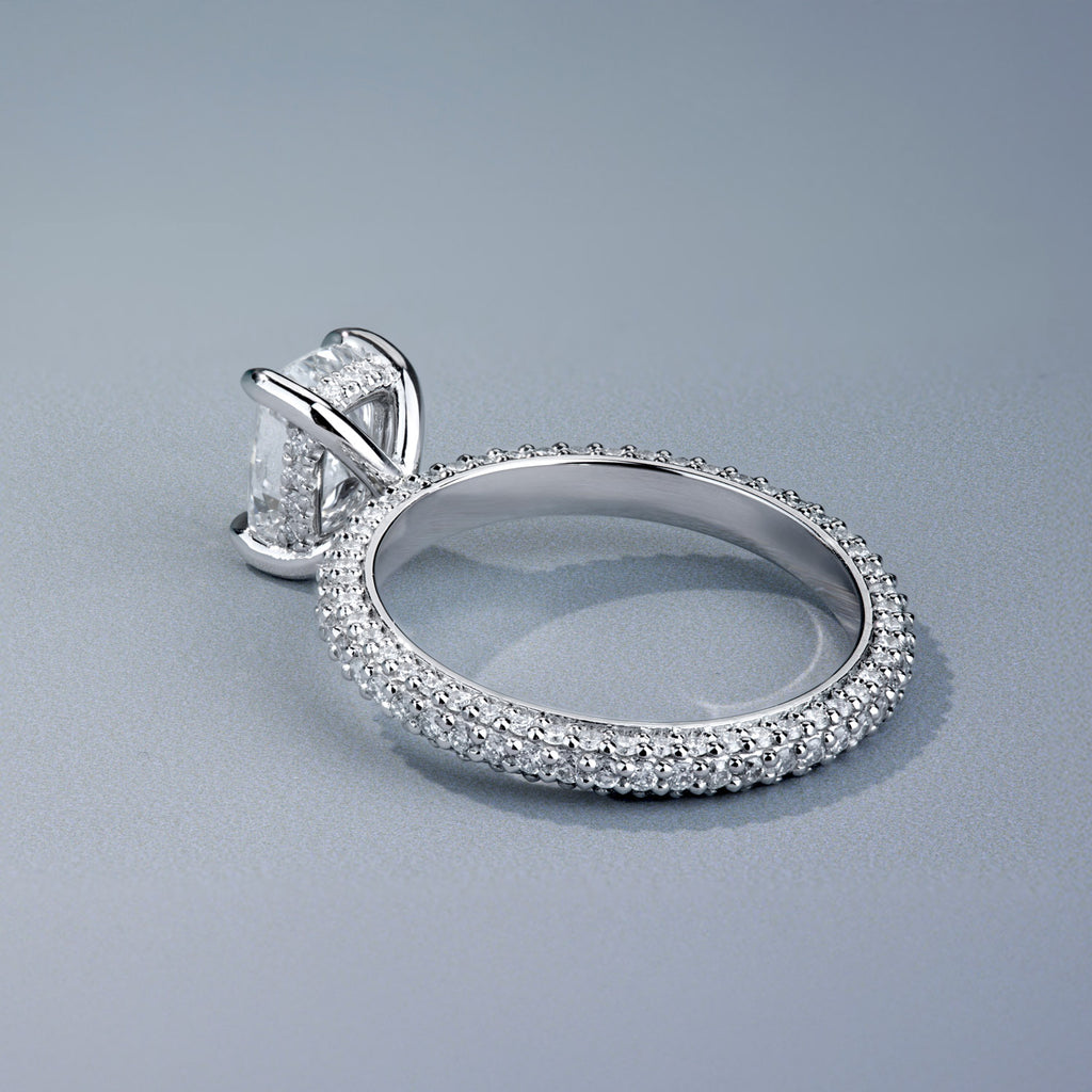 Canadian-made radiant-cut diamond engagement ring with a pavé diamond band and hidden halo set in 18K white gold.
