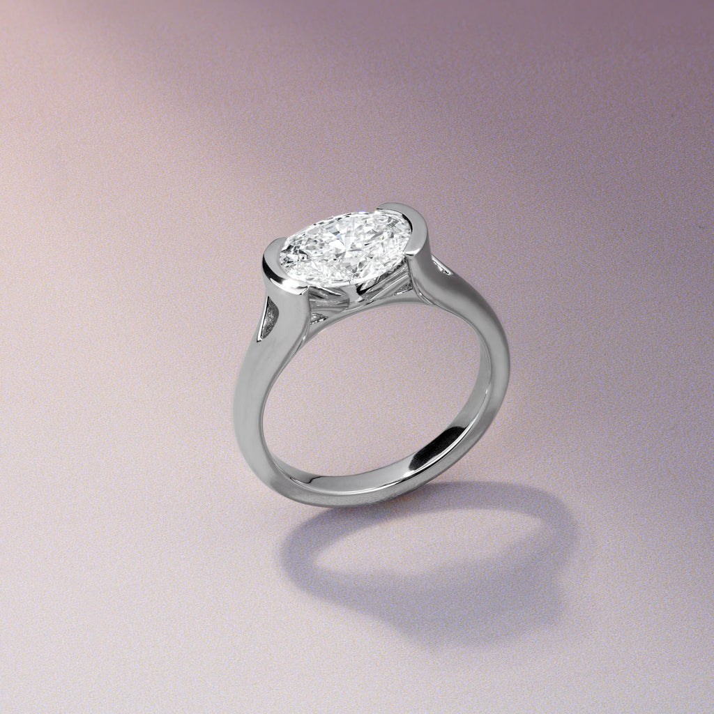 Canadian-made Ecksand engagement ring with an east-west oval diamond in a modern 18K white gold semi-bezel setting.