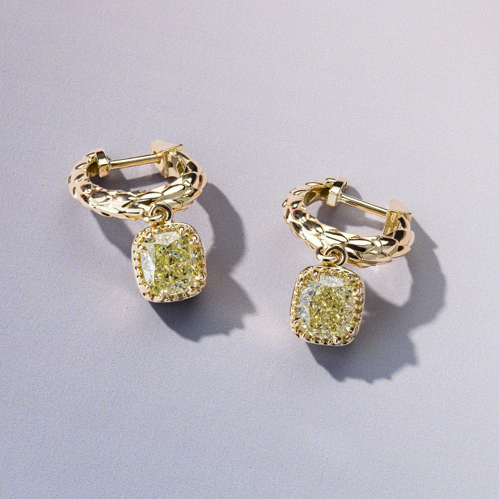 A pair of Canadian-made braided 18K yellow gold hoop earrings with dangling cushion-cut yellow diamond charms.