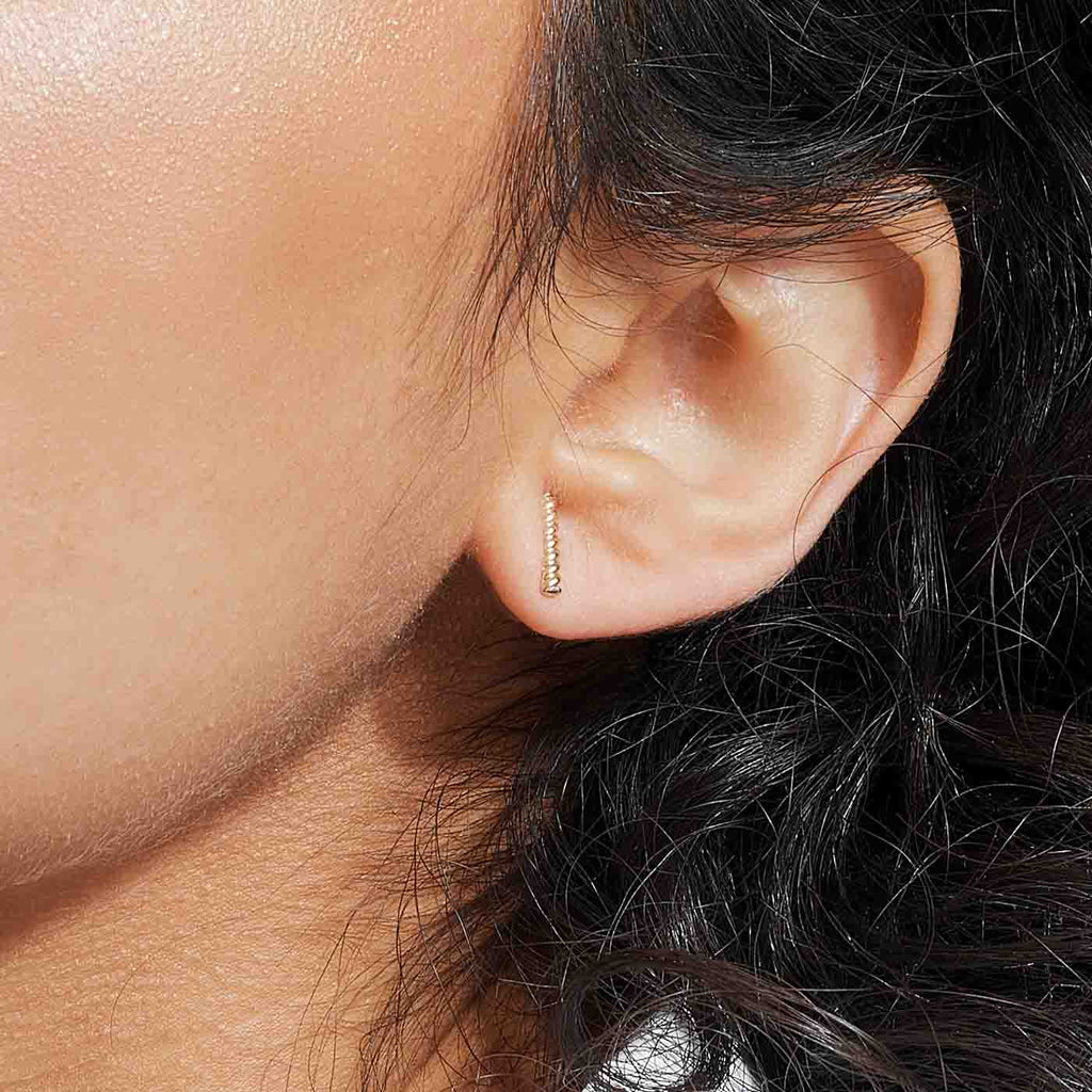The Ecksand Twisted Gold Bar Stud Earrings shown with  in 