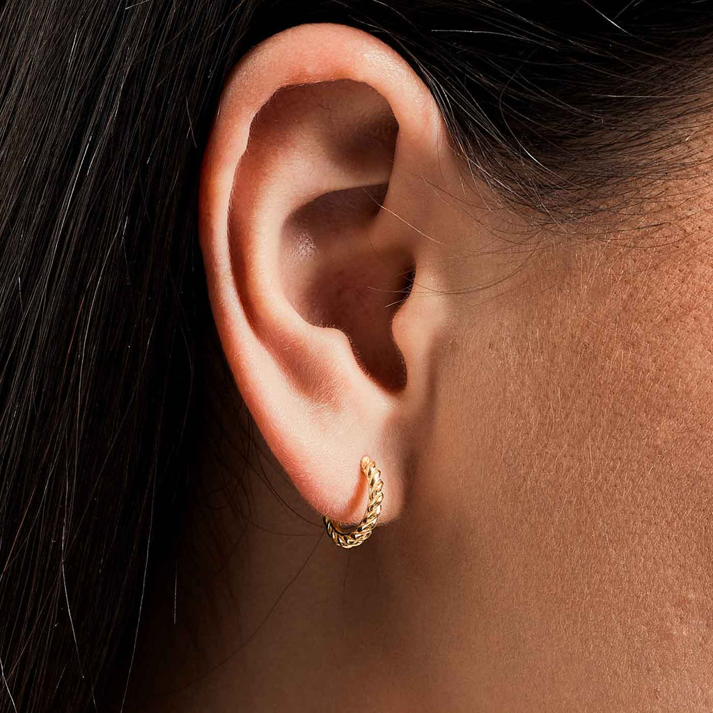 The Ecksand Twisted Gold Hoop Earrings shown with  in 