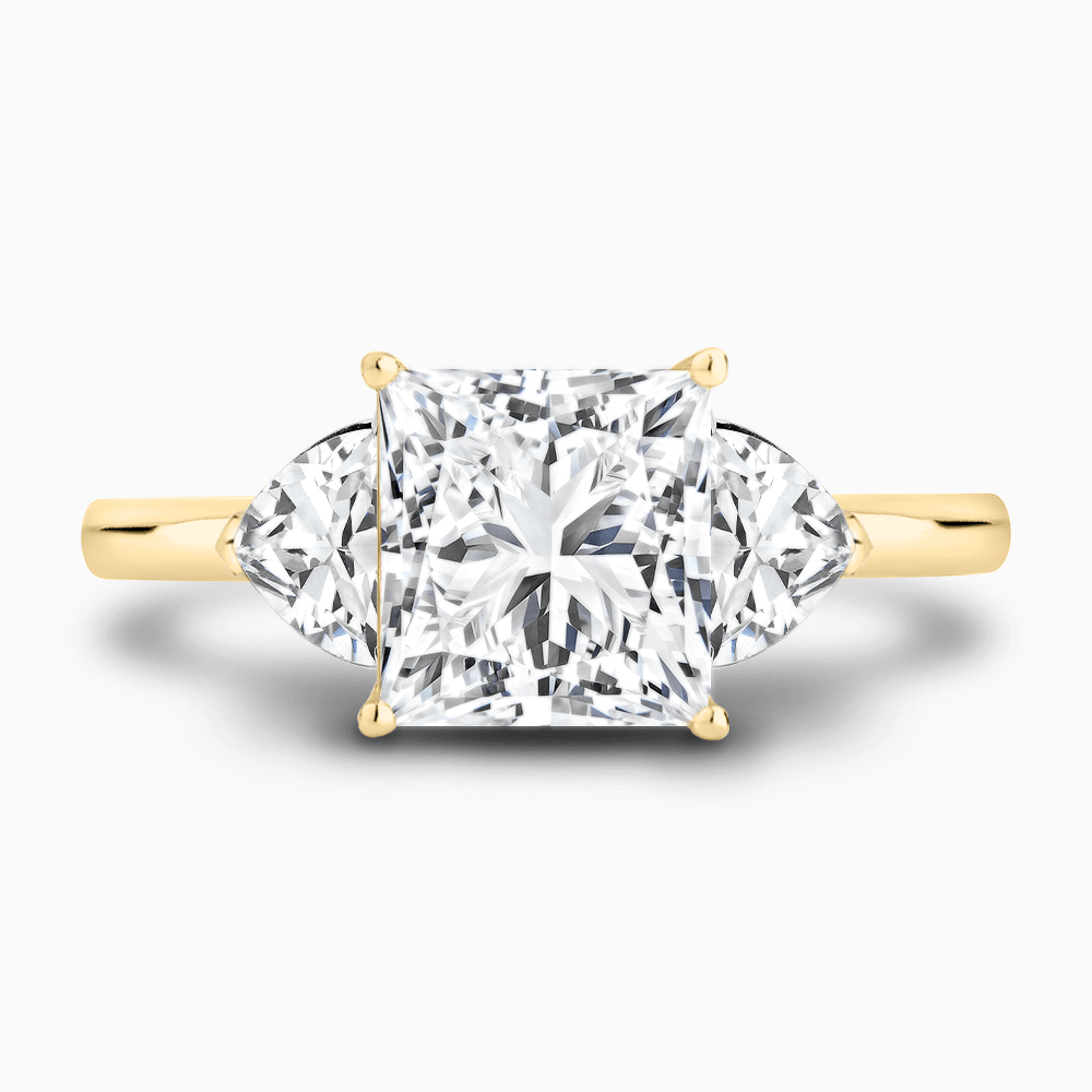 The Ecksand Three-Stone Diamond Engagement Ring with Trillion-Cut Side Diamonds shown with Princess in 18k Yellow Gold