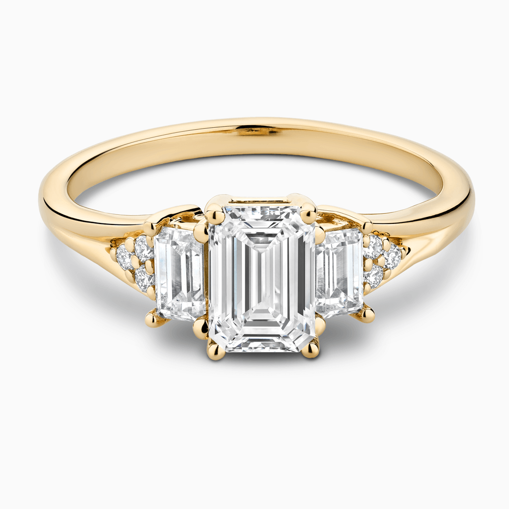 The Ecksand Three-Stone Engagement Ring with Side Diamonds shown with Emerald in 18k Yellow Gold